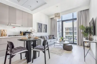 a kitchen and living room with a table and chairs at Frank Porter - Riviera 27 in Dubai