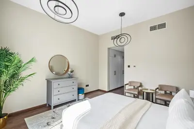 a bedroom with a white bed and a mirror at Luxury 1 Bedroom Apartment in Discovery Gardens in Dubai