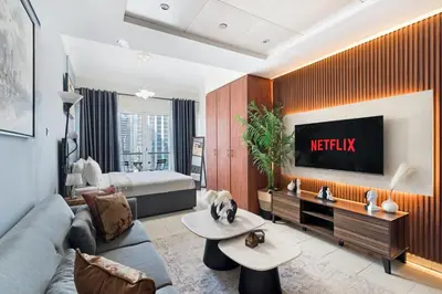 a living room with a couch and a tv at Modern JLT Studio Lake View 5min MetroMarina in Dubai