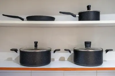 three pots on a stove in a kitchen at Modern JLT Studio Lake View 5min MetroMarina in Dubai