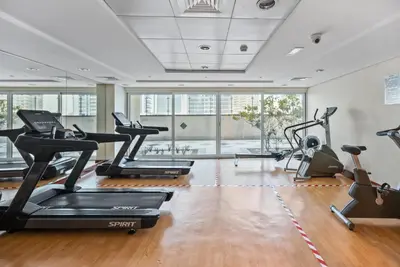 a gym with treadmills and elliptical machines at Modern JLT Studio Lake View 5min MetroMarina in Dubai