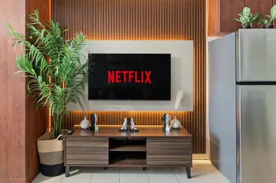 a tv with the netflix sign on a wall at Modern JLT Studio Lake View 5min MetroMarina in Dubai
