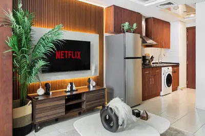 a kitchen with a television on a wall at Modern JLT Studio Lake View 5min MetroMarina in Dubai