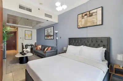 a bedroom with a large bed and a couch at Modern JLT Studio Lake View 5min MetroMarina in Dubai