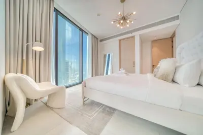 a white bedroom with a large bed and a chair at Address JBR Marina View, JBR, Dubai Marina - Mint Stay in Dubai