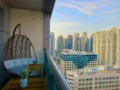 a balcony with a chair and a view of the city at 35% OFF in Top View Studio w/ Balcony in Marina in Dubai