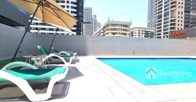 a swimming pool with lounge chairs and an umbrella at 35% OFF in Top View Studio w/ Balcony in Marina in Dubai