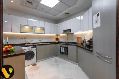 a kitchen with a washing machine and a washer at Vogue Business Bay, Bayz By Danube close to Downtown, Dubai Mall and Burj Khalifa, Three Bedroom Apartment with Balcony and Burj Khalifa view, Access to all Amenities in Dubai