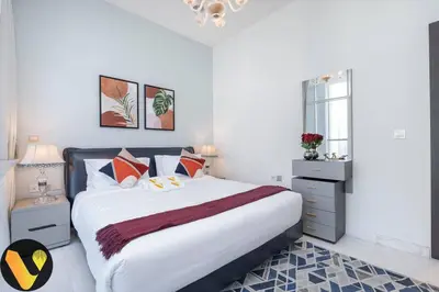 a white bedroom with a large bed with pillows at Vogue Business Bay, Bayz By Danube close to Downtown, Dubai Mall and Burj Khalifa, Three Bedroom Apartment with Balcony and Burj Khalifa view, Access to all Amenities in Dubai