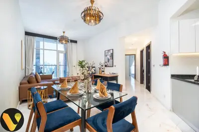 a living room with a glass table and blue chairs at Vogue Business Bay, Bayz By Danube close to Downtown, Dubai Mall and Burj Khalifa, Three Bedroom Apartment with Balcony and Burj Khalifa view, Access to all Amenities in Dubai