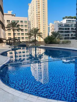 a large blue swimming pool in a city with buildings at Dream Tower 1 in Dubai