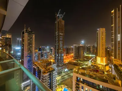 a city skyline at night with tall buildings at Elegant 1BR in Downtown, Close to Dubai Mall in Dubai