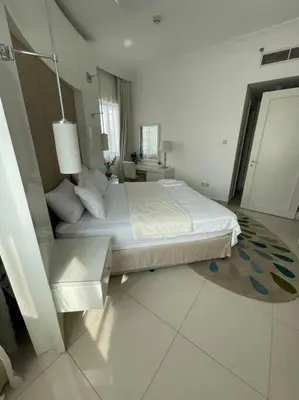 a white bedroom with a bed and a window at Elegant 1BR in Downtown, Close to Dubai Mall in Dubai