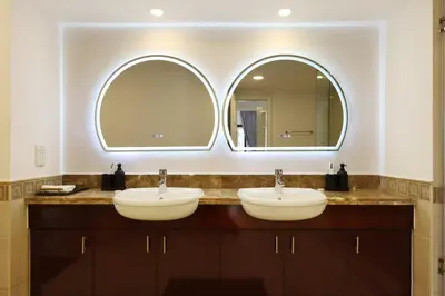 two sinks in a bathroom with two mirrors at 1BR in Palm Jumeirah, Walk to the Beach and Mall in Dubai