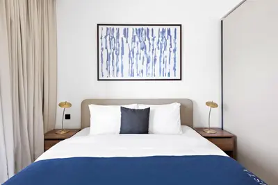 a bedroom with a blue and white bed with two lamps at Silkhaus Marina View with Tower's Private Beach in Dubai