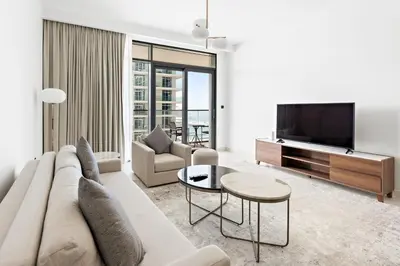 a living room with a couch and a tv at Silkhaus Marina View with Tower's Private Beach in Dubai
