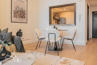 a kitchen and living room with a table and chairs at Chic 1 Bed in Marina Newly Furnished,Modern Luxury in Dubai