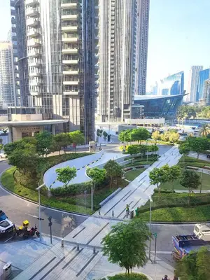 a park in the middle of a city with tall buildings at Luxury 2 Bedroom Apartment - Next to Dubai Opera in Dubai