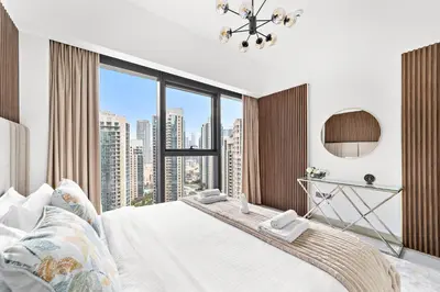 a bedroom with a white bed with a large window at Luxury 2 Bedroom Apartment - Next to Dubai Opera in Dubai