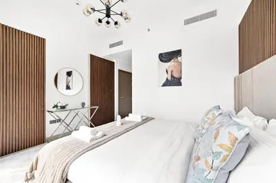 a bedroom with a large white bed and a chandelier at Luxury 2 Bedroom Apartment - Next to Dubai Opera in Dubai