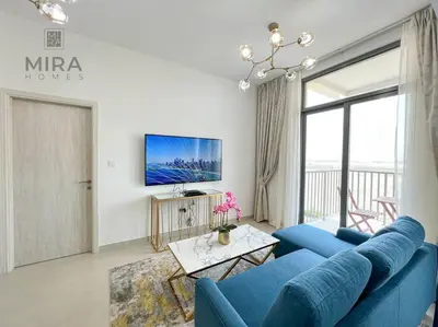 a living room with a blue couch and a tv at Mira Holiday Homes - Serviced 1 bedroom in Midtown in Dubai