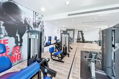 a gym with cardio machines and a wall with a poster at Botanica Tower - Bright One Bedroom in Dubai