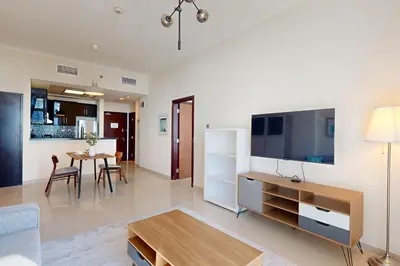 a living room with a large television and a table at Botanica Tower - Bright One Bedroom in Dubai