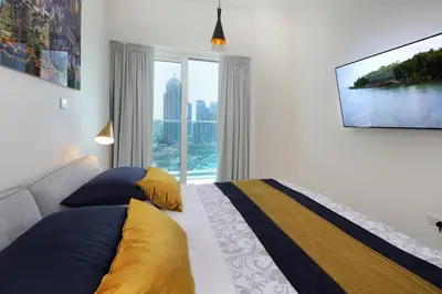 a bedroom with a bed and a large window at AHH - Panoramic Marina Views - Stylish 2BR at DAMAC Heights in Dubai