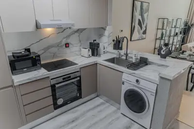 a kitchen with a sink and a washing machine at Clever Guest Concorde JLT in Dubai