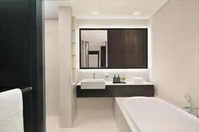a bathroom with a tub and a sink and a mirror at Sheraton Grand Hotel, Dubai in Dubai