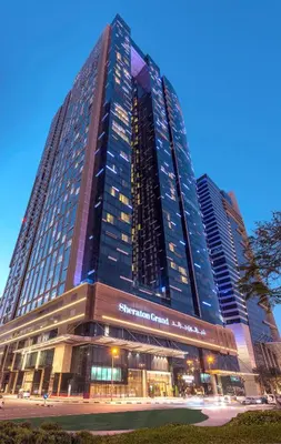 a tall building with a sign in front of it at Sheraton Grand Hotel, Dubai in Dubai