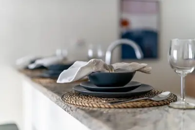 a table with a black bowl and a glass of wine at GuestReady Holiday Homes - One Mint Sunset in Dubai