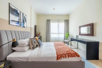 a bedroom with a large bed and a desk at GuestReady Holiday Homes - One Mint Sunset in Dubai