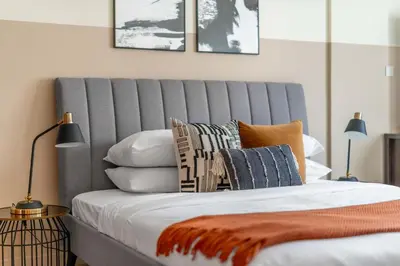 a bedroom with a bed with pillows on it at GuestReady Holiday Homes - One Mint Sunset in Dubai