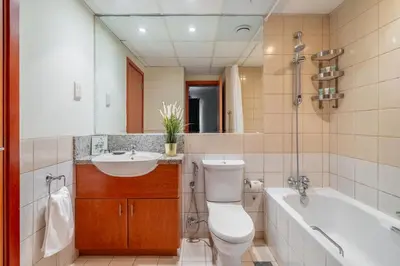 a bathroom with a toilet and a sink and a tub at GuestReady Holiday Homes - One Mint Sunset in Dubai