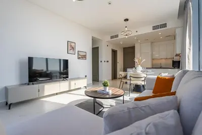 a living room with a couch and a table at Residence 12 I District One I 1 Bedroom Apartment in Dubai