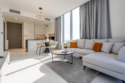 a living room with a couch and a table at Residence 12 I District One I 1 Bedroom Apartment in Dubai