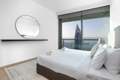 a white bedroom with a large bed and a mirror at Vacay Lettings - Burj Vista Tower 1- Direct Dubai Mall Access in Dubai