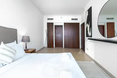 a bedroom with a white bed and a mirror at Vacay Lettings - Burj Vista Tower 1- Direct Dubai Mall Access in Dubai