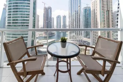 a balcony with a table and chairs and a view of the city at GuestReady Holiday Homes - Hibernate Hideout in Dubai