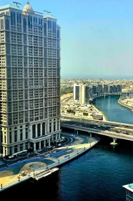 a large building next to a river with a bridge at RH- Beautiful Canal View, Cozy studio near metro station in Dubai