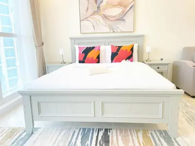 a large white bed in a white bedroom at RH- Beautiful Canal View, Cozy studio near metro station in Dubai