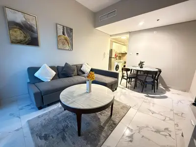 a living room with a couch and a table at StoneTree - Cozy and Modern 1 BR in Dubai