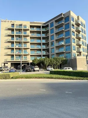 a large apartment building with cars parked in a parking lot at StoneTree - Cozy and Modern 1 BR in Dubai