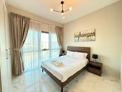a bedroom with a bed and a large window at StoneTree - Cozy and Modern 1 BR in Dubai