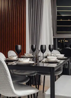 a black dining table with white chairs and glasses at Sky High Gem in Central Dubai with Burj Khalifa and Fountain Views in Dubai