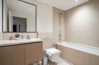 a bathroom with a tub and a toilet and a sink at Sky High Gem in Central Dubai with Burj Khalifa and Fountain Views in Dubai