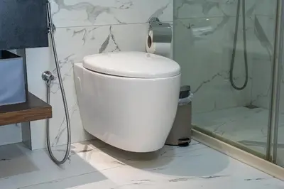 a white toilet in a bathroom with a shower at Luxury & Stylish Studio - JVC in Dubai