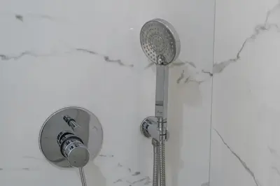 a shower with a shower head on a wall at Luxury & Stylish Studio - JVC in Dubai