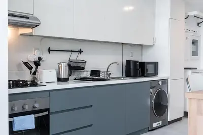 a kitchen with a stove and a washing machine at Luxury & Stylish Studio - JVC in Dubai